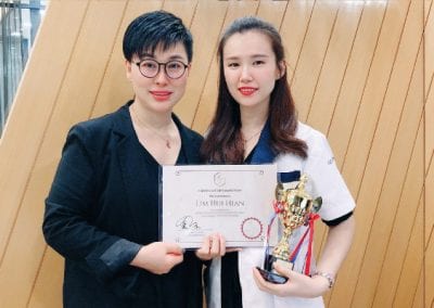 the macqueen Nicole lim with PCL trainer holding certificate and trophy